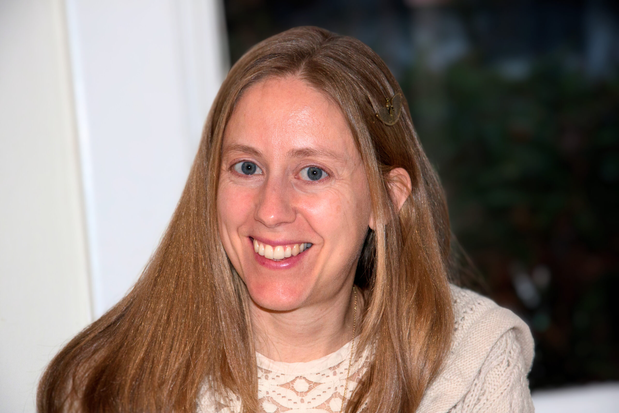 A smiling white woman with long blonde hair and blue eyes.