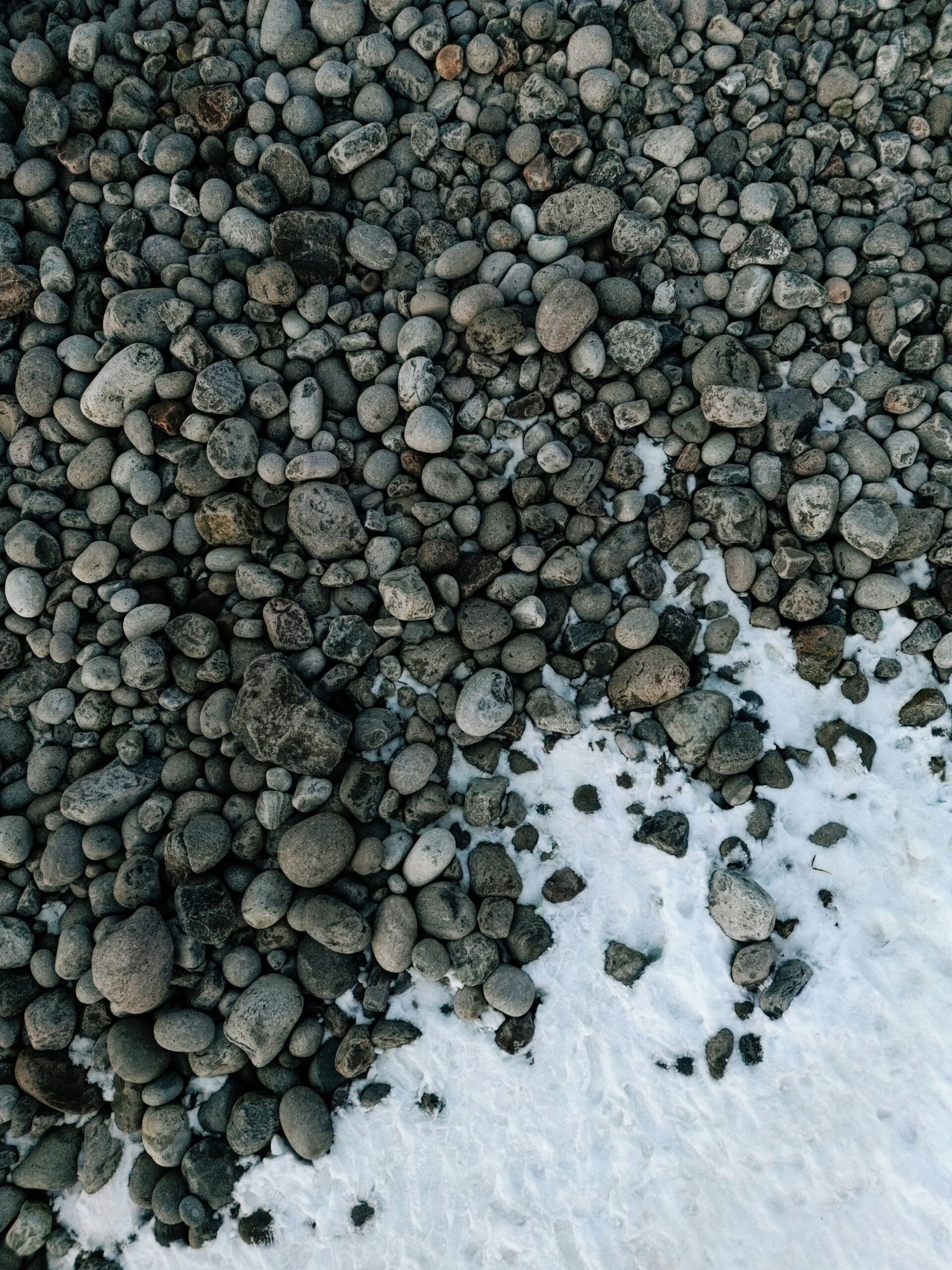 Gray rocks on snow covered ground. 